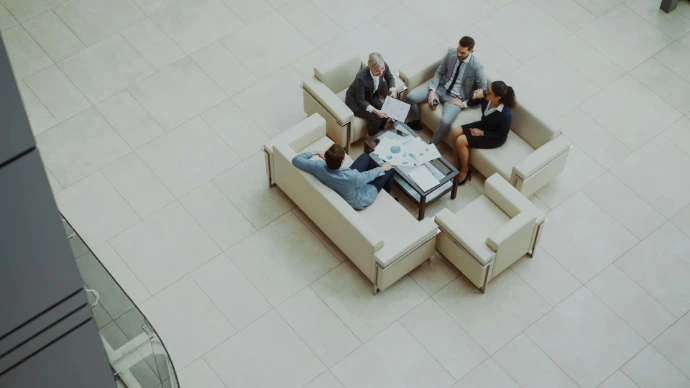 Business people meeting on sofas in a modern lobby.